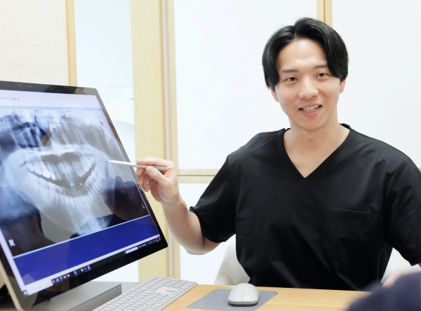 モニターを使って歯科治療について解説してる歯科医師