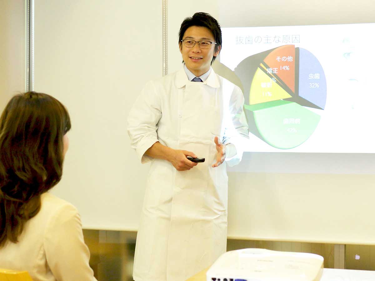 歯抜けの放置で更に歯を失うリスクが高まる説明をする歯科医師